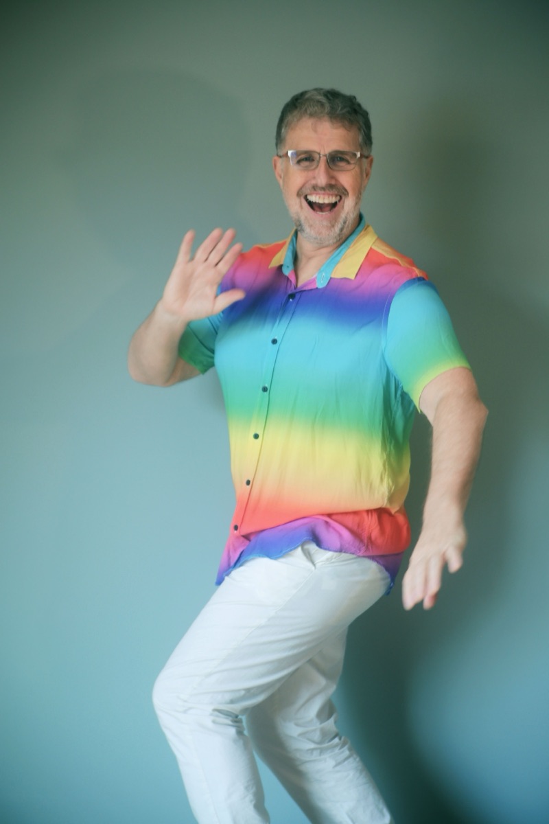 Michel Tasky sorrindo, de camisa colorida